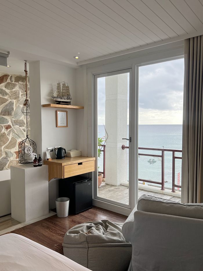 Charming room with a sea view through large windows and a cozy interior.